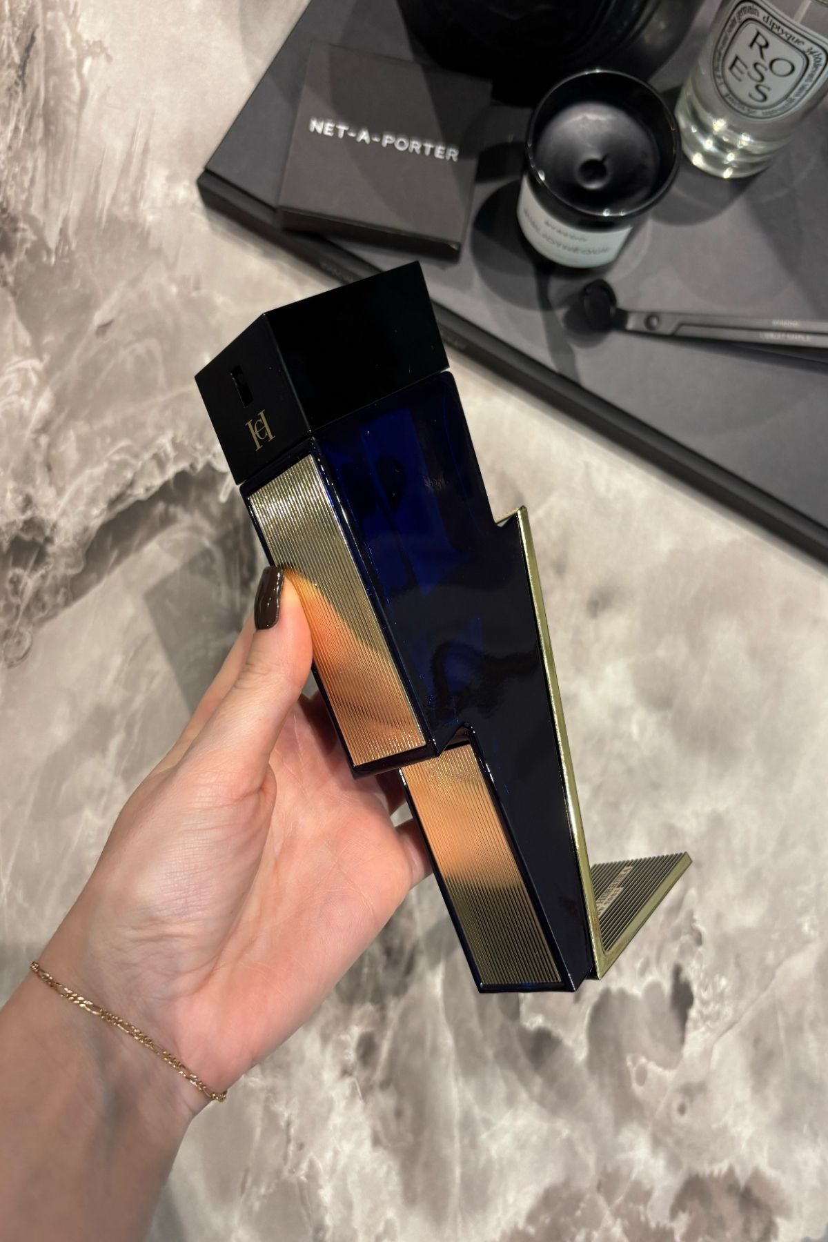 Deputy beauty editor Grace Lindsay holding a bottle of Carolina Herrera Bad Boy Cobalt