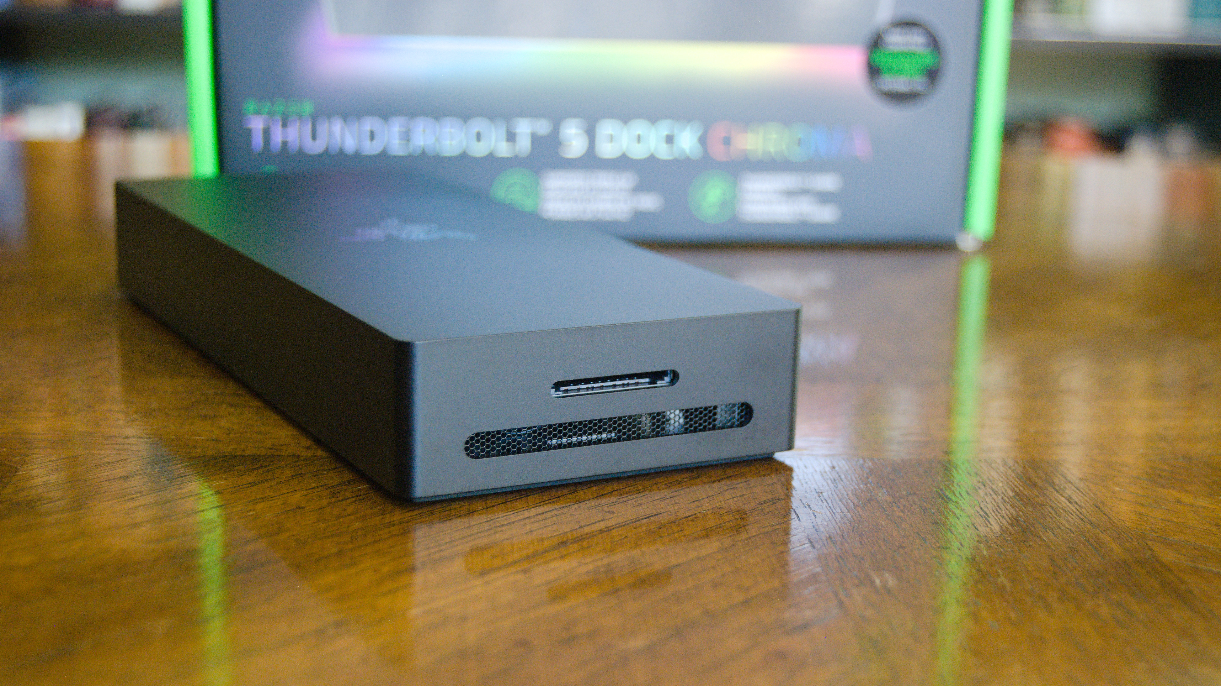 The Razer Thunderbolt 5 Dock Chroma sitting on a table with a side vent and the UHS-II SD card reader in view.