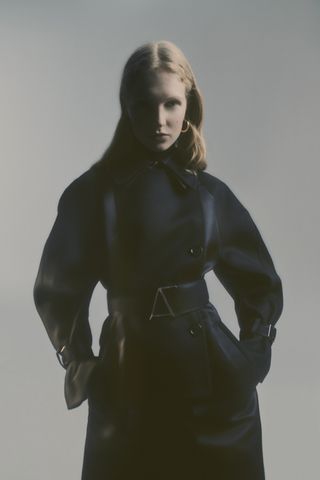 Woman facing camera in trench coat