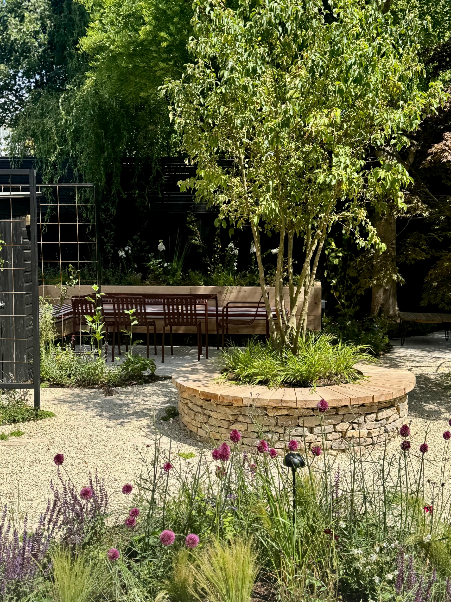 a garden with a central round planter seat in a Mediterranean garden