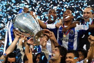 Porto's Benni McCarthy (top L) and Carlos Alberto (top R) hold the trophy as they celebrate with their teamates after beating Monaco 3-0 in the Champions League final football match, 26 May 2004 at the Arena AufSchalke stadium in Gelsenkirchen.