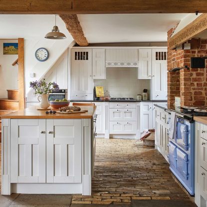 traditional farmhouse kitchen with stone floor, cream units and range cooker