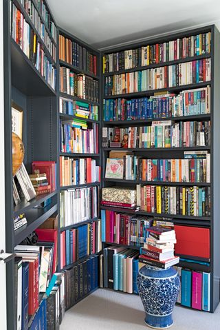 Black bookcase built into the corner of a small room