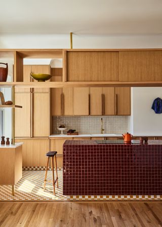 Red tiled kitchen island by GRT Architects