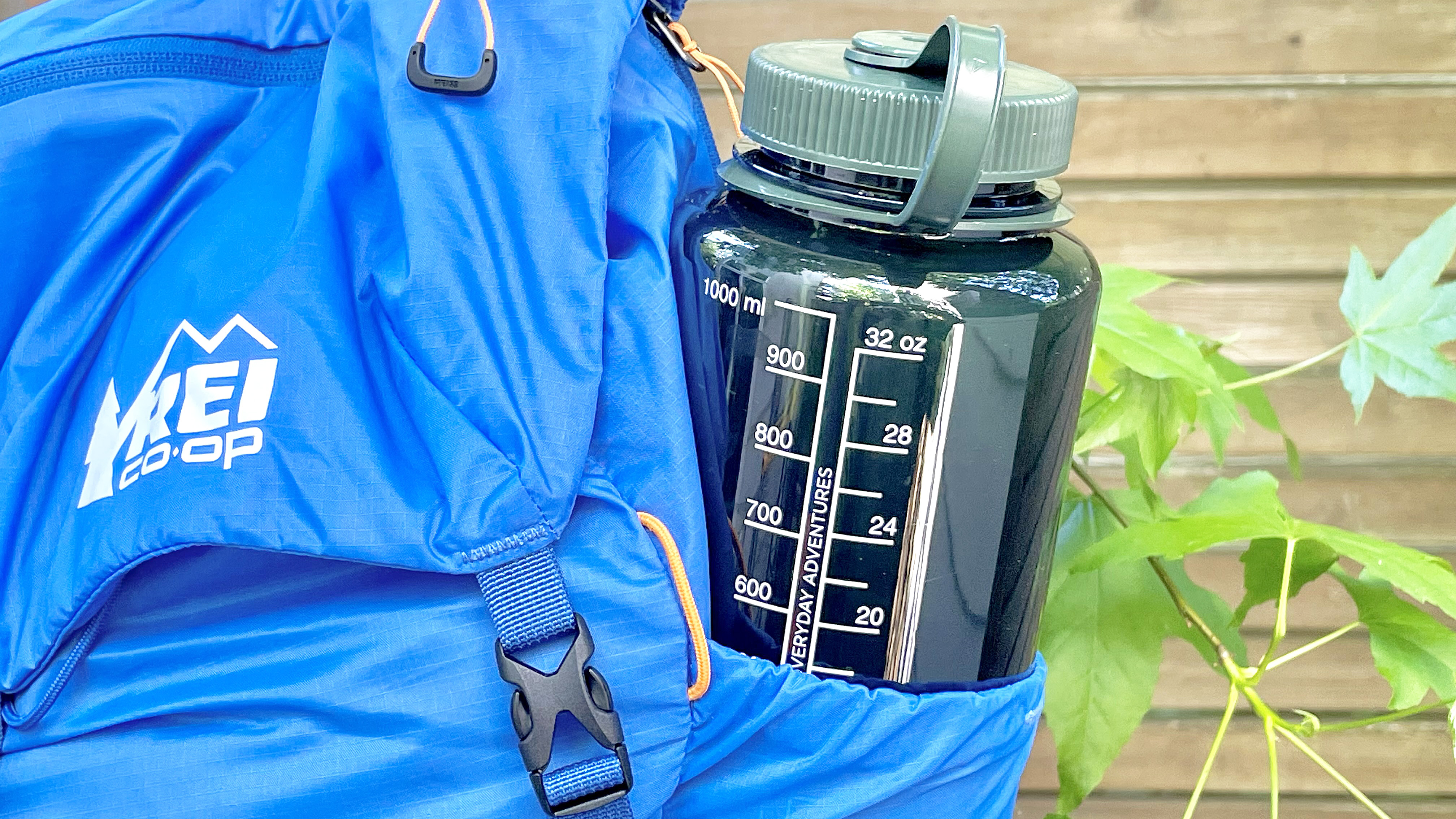 Close-up of a Nalgene water bottle in the pocket of a blue hiking backpack