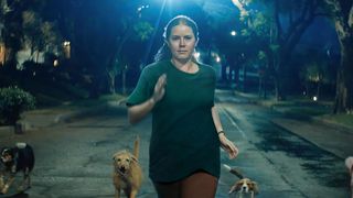 Amy Adams' Mother runs down the street flanked by dogs in Nightbitch