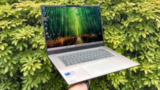 MSI Prestige 16 AI+ on hand with green bush in background