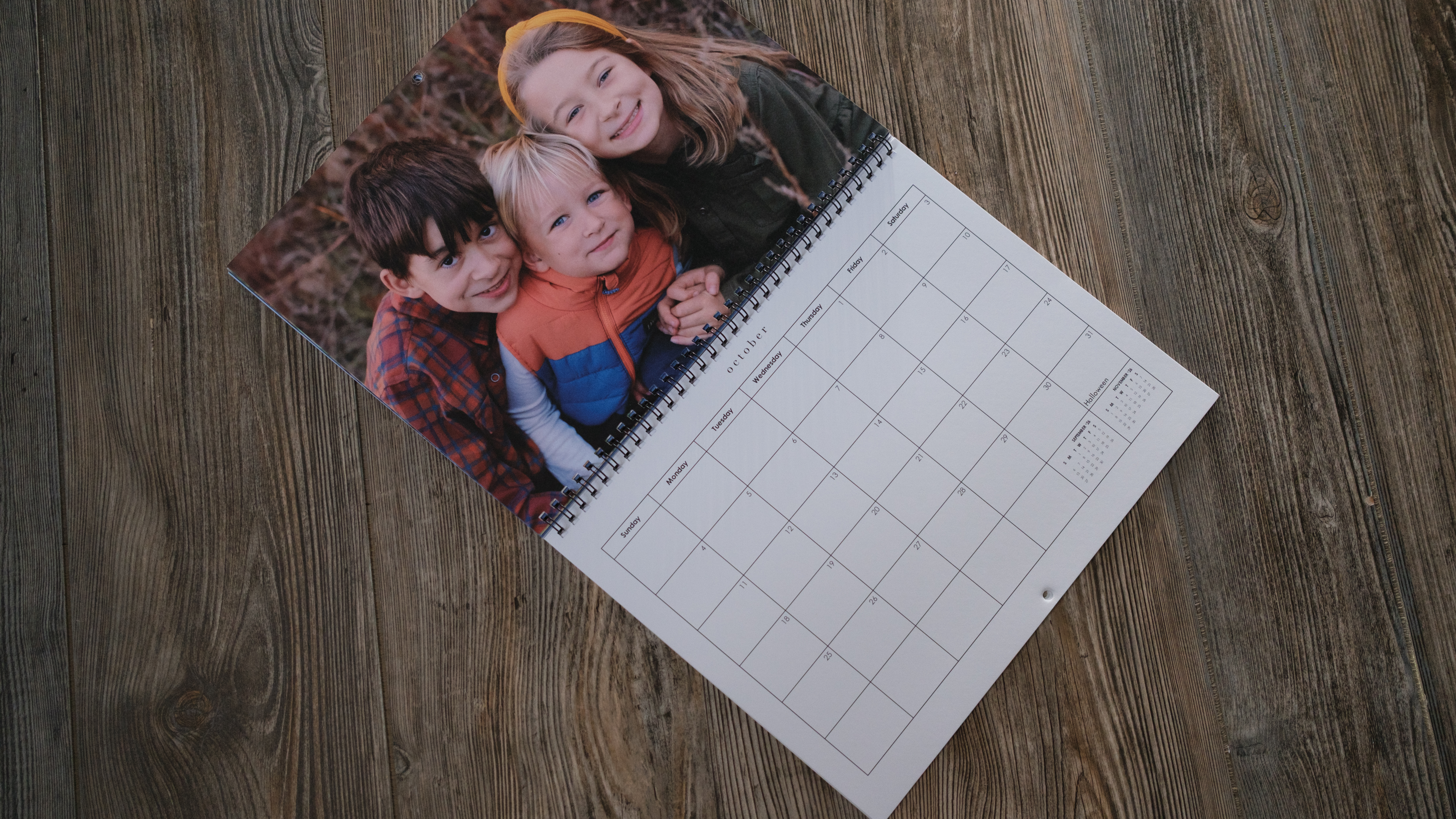 A photo calendar from Mixbook on a wood background