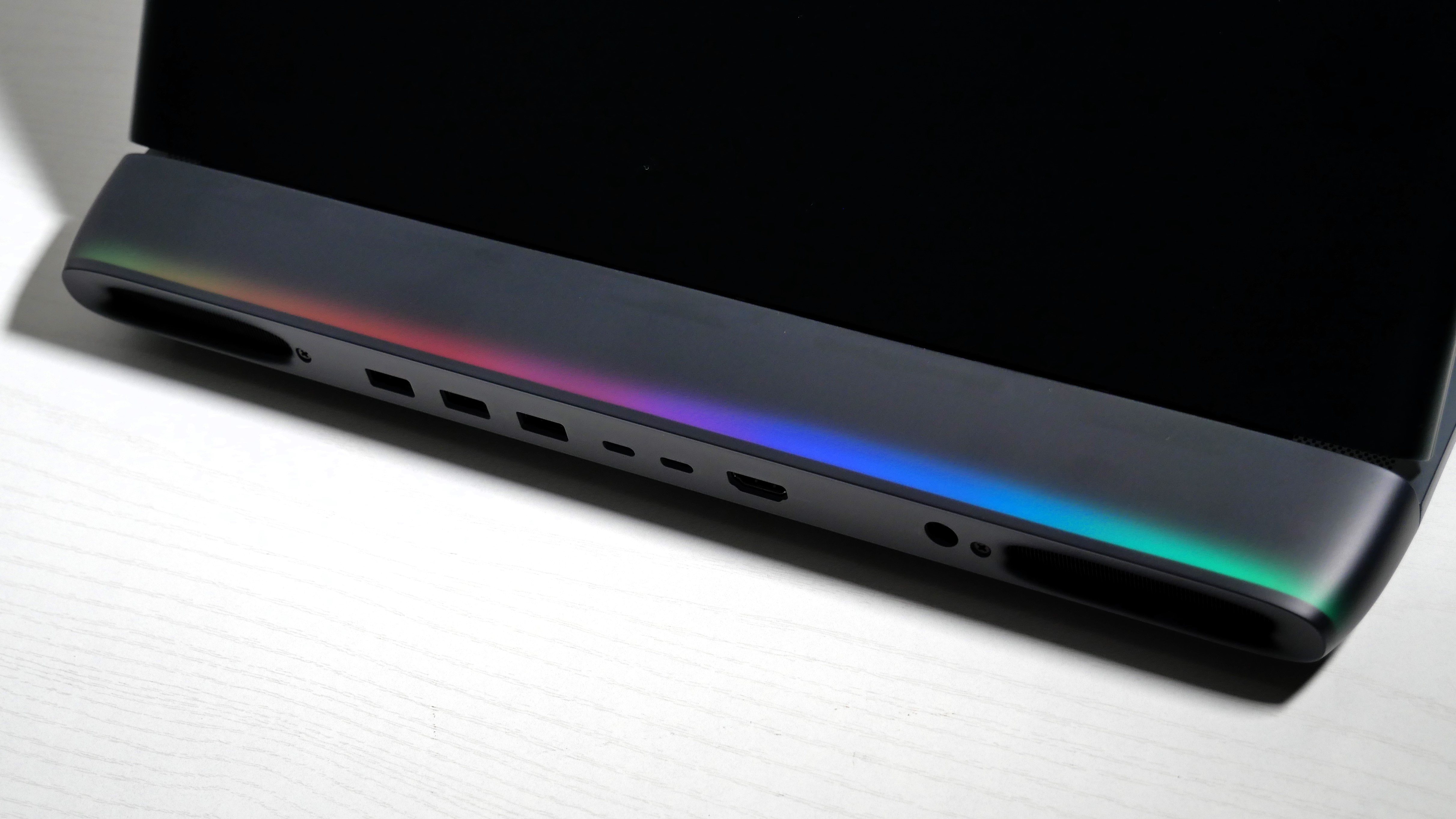 Alienware 16 Area-51 (RTX 5080) open on a white desk, highlighting the light bar on the hinge.