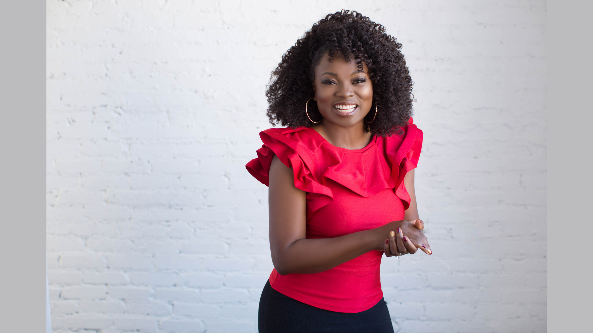A photo of Yummy Spoonfuls founder Agatha Achindu posing in front of a white wall.
