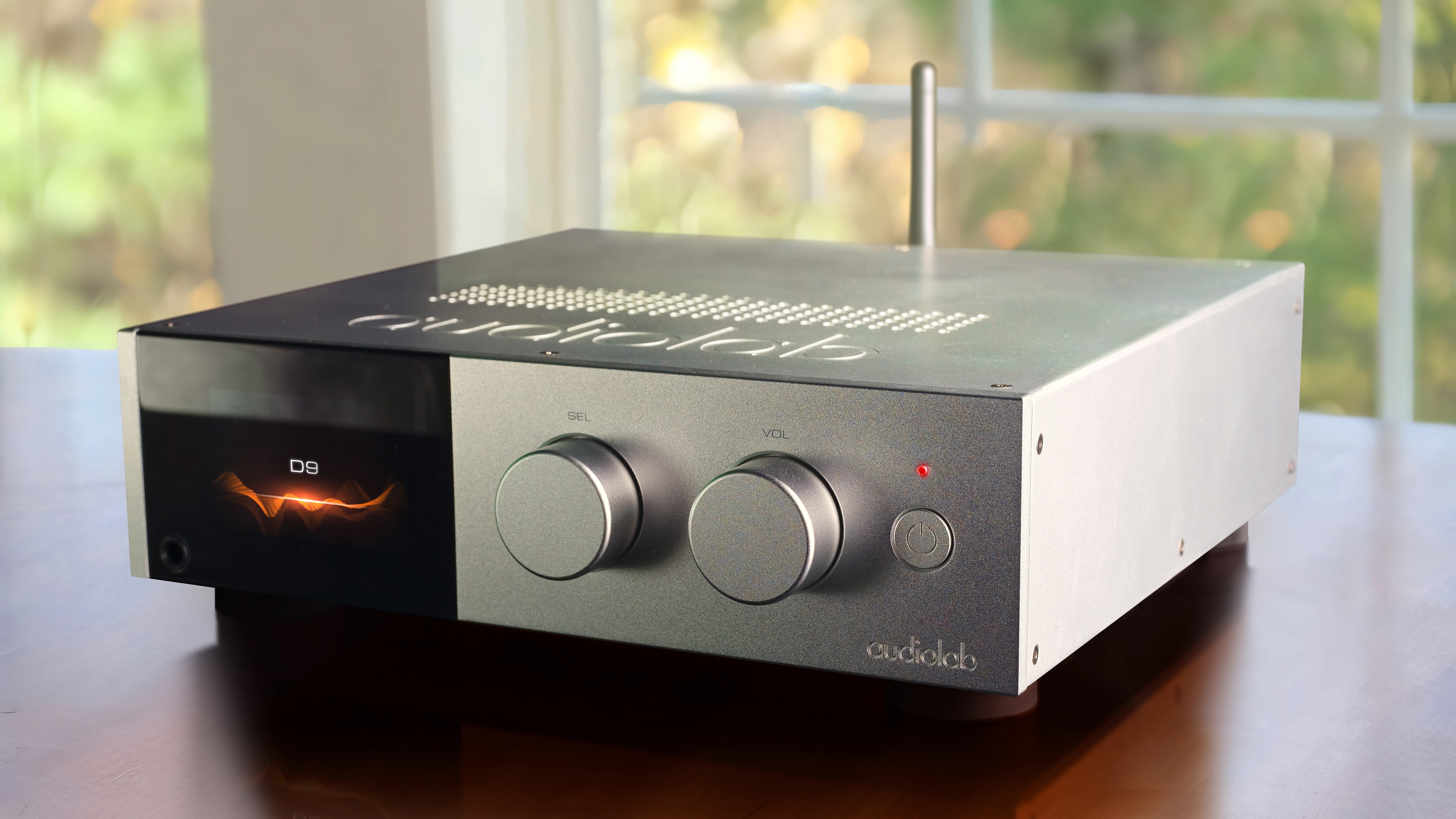 Audiolab D9 DAC in silver finish placed on table
