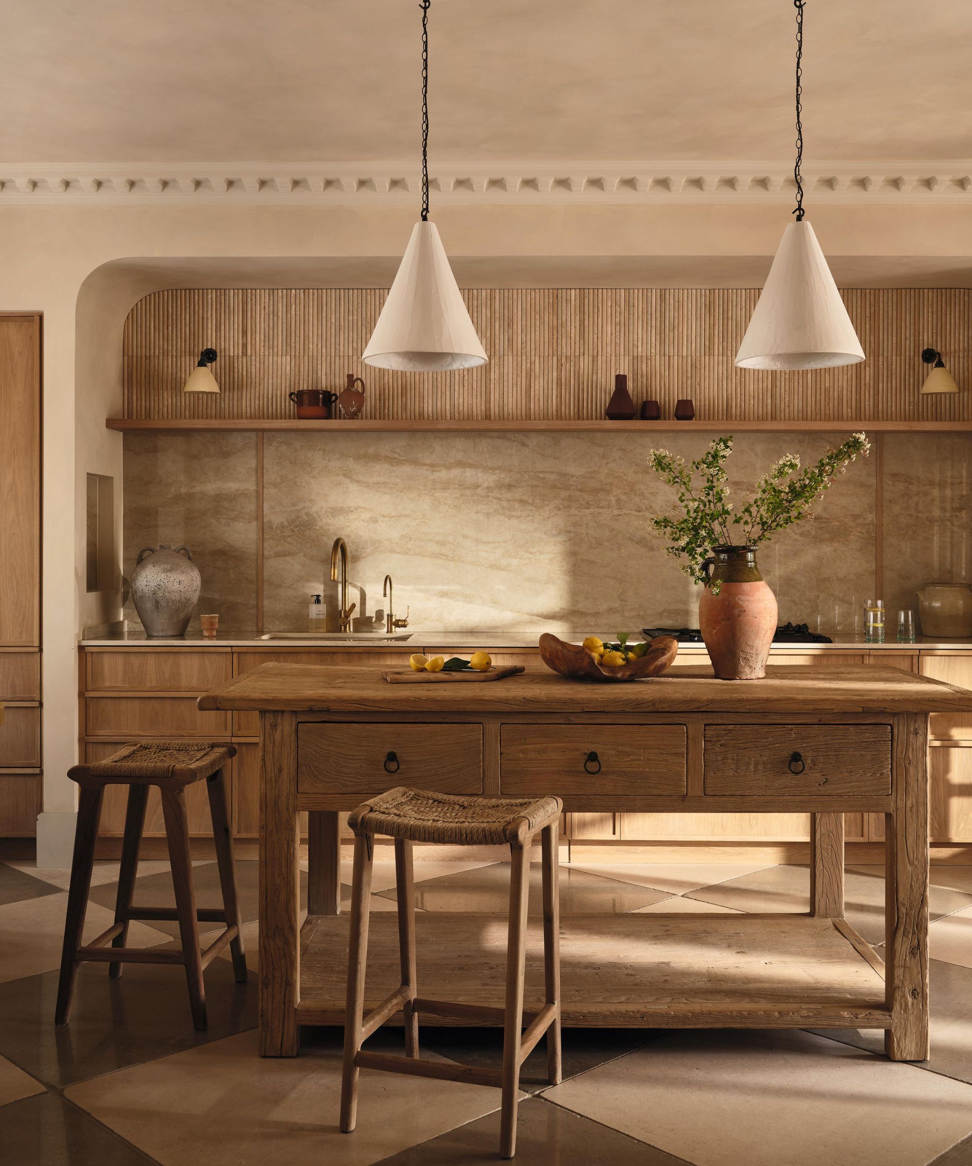 a warm oak textured kitchen with a freestanding rustic island, checkerboard tiled floor and plaster pendant lights