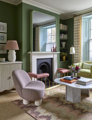 A living room with a beige carpet, and a printed carpet on top