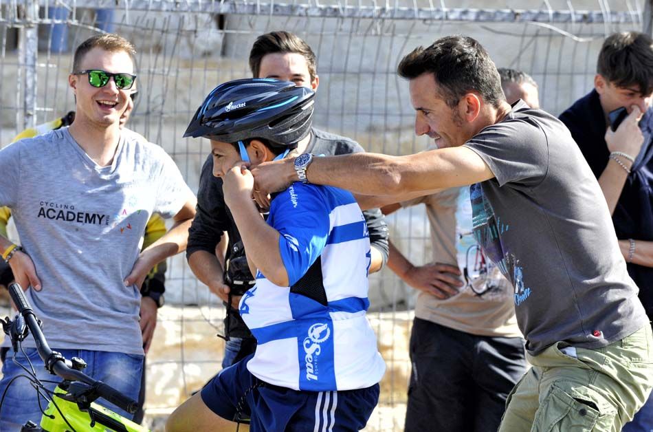 Ruben Plaza helps one of the children put on a helmet