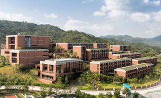 A photo overlooking the estate of Xiao Jing Wan University surrounded by green hills.