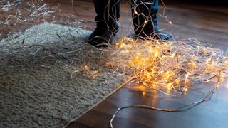 Unraveling Christmas lights on a wooden floor