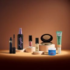 A selection of beauty products against an orange-brown background and a spot light shining down