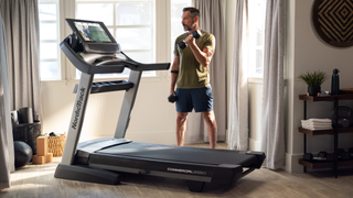 Man working out beside NordicTrack Commercial 2950 treadmill