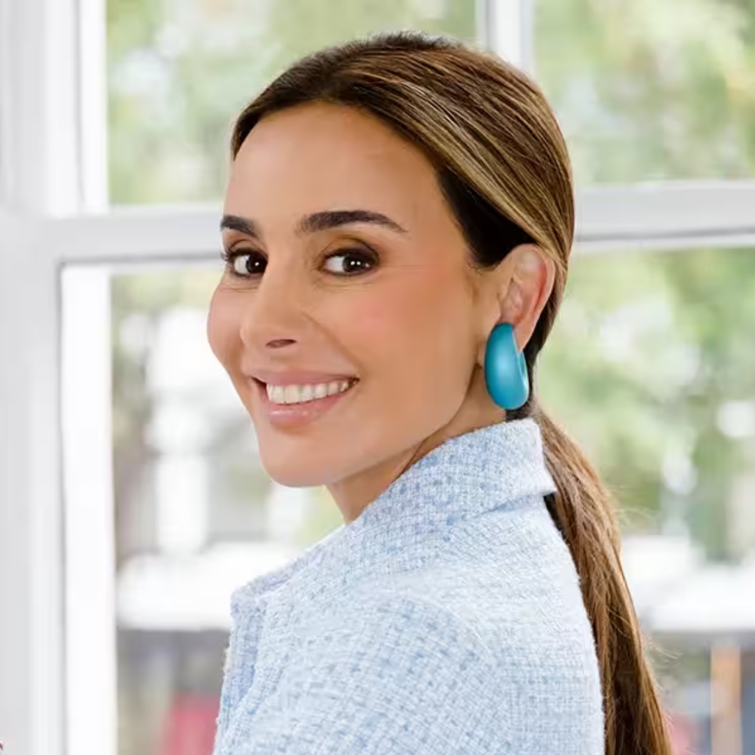 Image of Dr Maryam Zamani smiling over one shoulder, with blonde-highlighted brunette straight hair tied in a ponytail