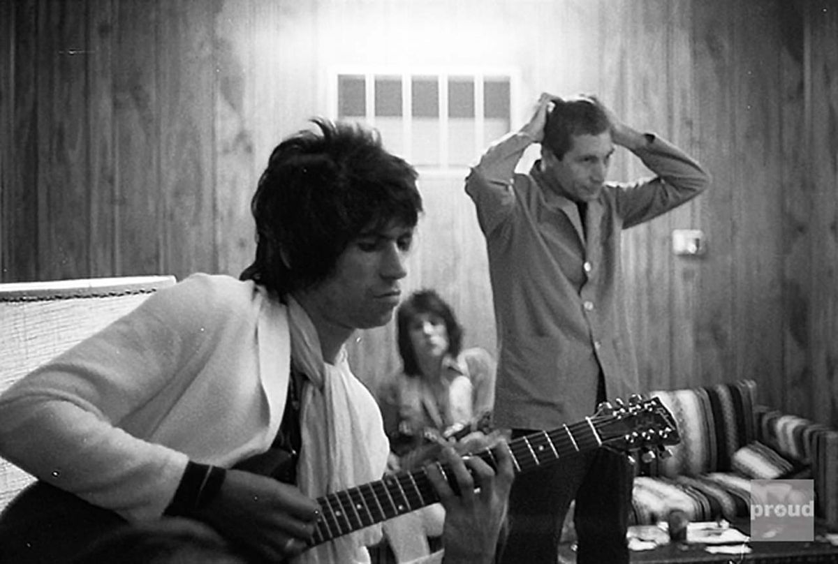 Keith Richards tuning up, backstage with Charlie Watts and Ronnie Wood, before a concert at Folsom Field Arena. Boulder, Colorado, 17th July 1978