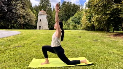 Woman in yoga pose on a mat in her garden