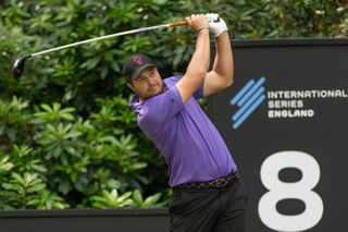 Peter Uihlein strikes a tee shot in front of a board