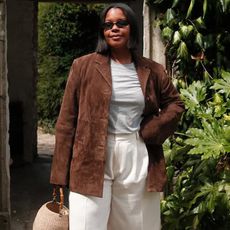 @styleidealist wears a tan suede jacket with cream Bermuda shorts and silver sandals