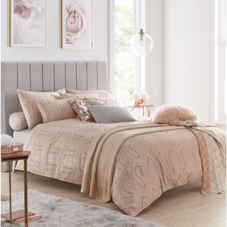 bedroom interior with pink wall and bedding with pink cushions