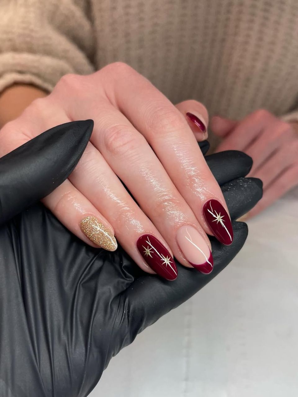 An image featuring a star-inspired burgundy nail design, courtesy of @nailsbyjesshales