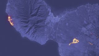 A night time satellite image of Maui with a bright yellow patch representing where the flames were