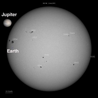 This composite image shows the sun's active region AR1654 (marked) compared to the sizes of the Earth and Jupiter. Image posted by NASA Solar Dynamics Observatory outreach officials Jan. 9, 2013.