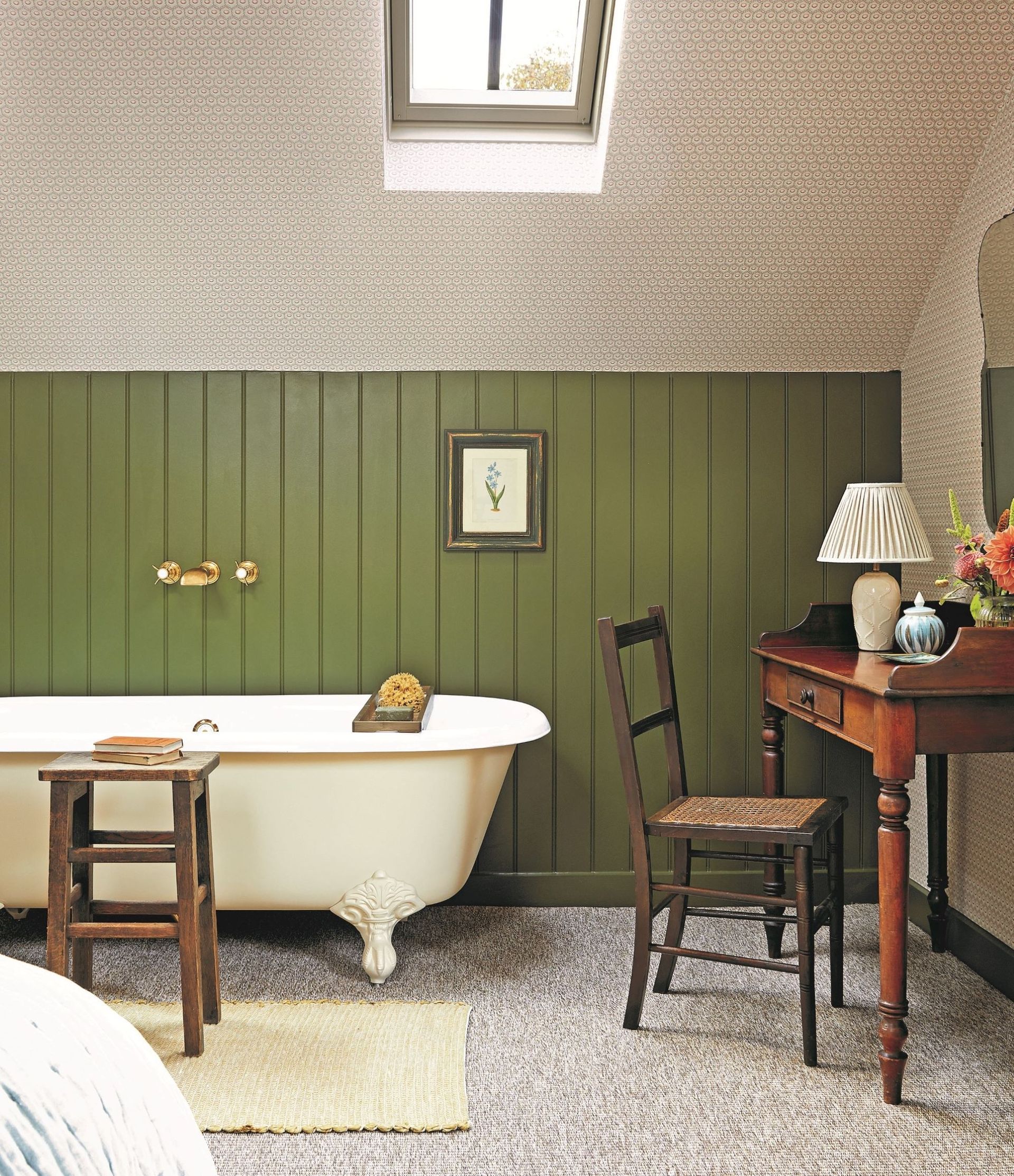 bedroom with white bathtub, green tongue and groove panelling and patterned wallpaper