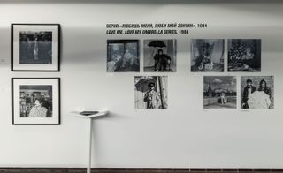 Numerous black and white photographs on white wall