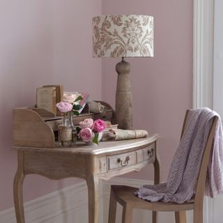 home office with wooden table and chair and pink wall