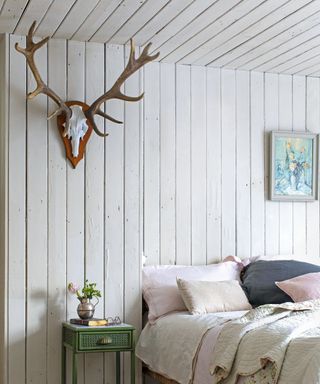 Scandi-cabin style bedroom featuring light wood paneling on wall and ceiling