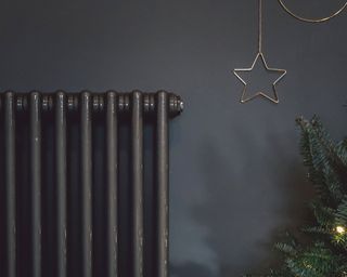 Grey radiator against grey wall with Christmas tree