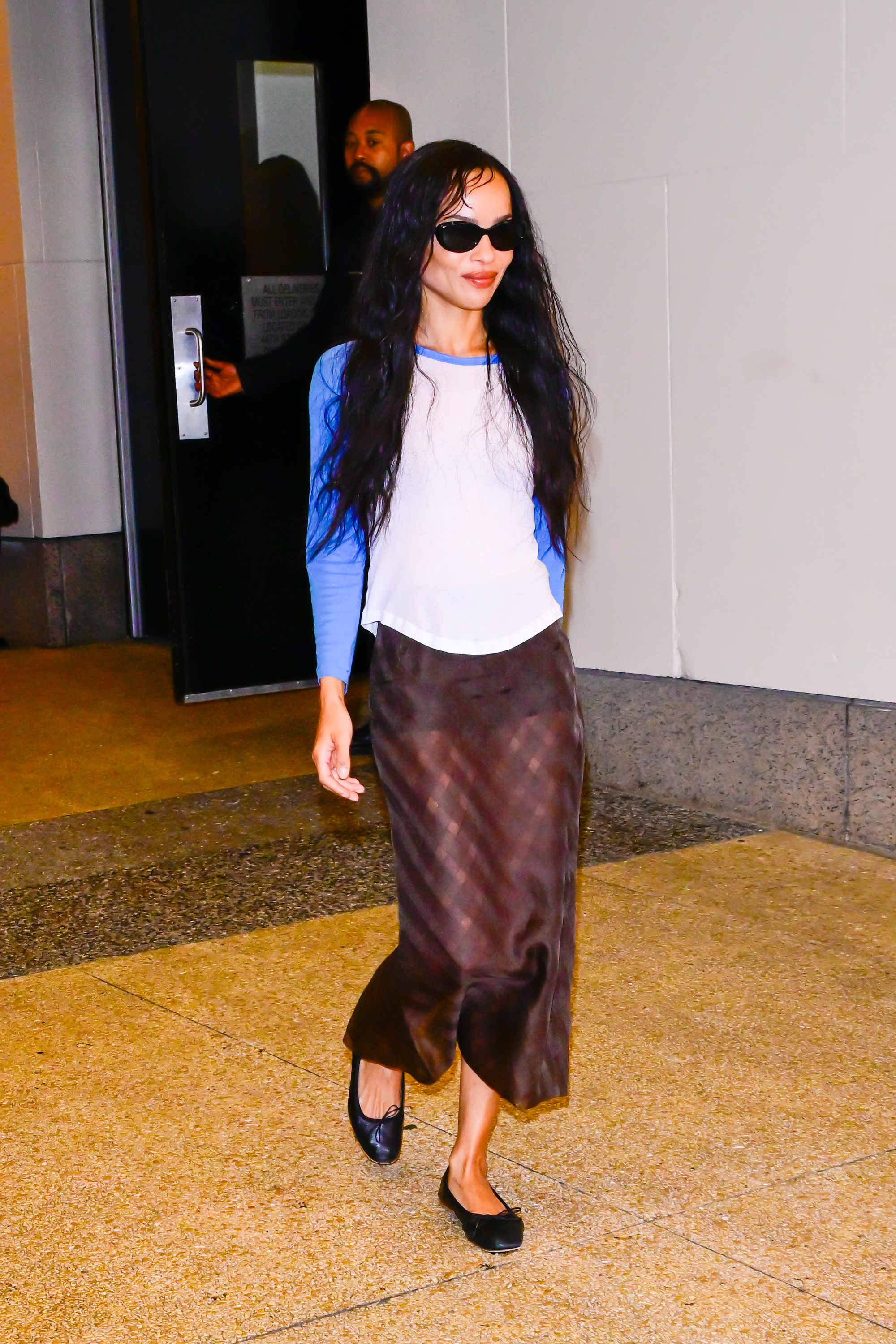 Zo&amp;euml; Kravitz wears a baseball shirt with a sheer checked skirt and ballet flats while out in New York.