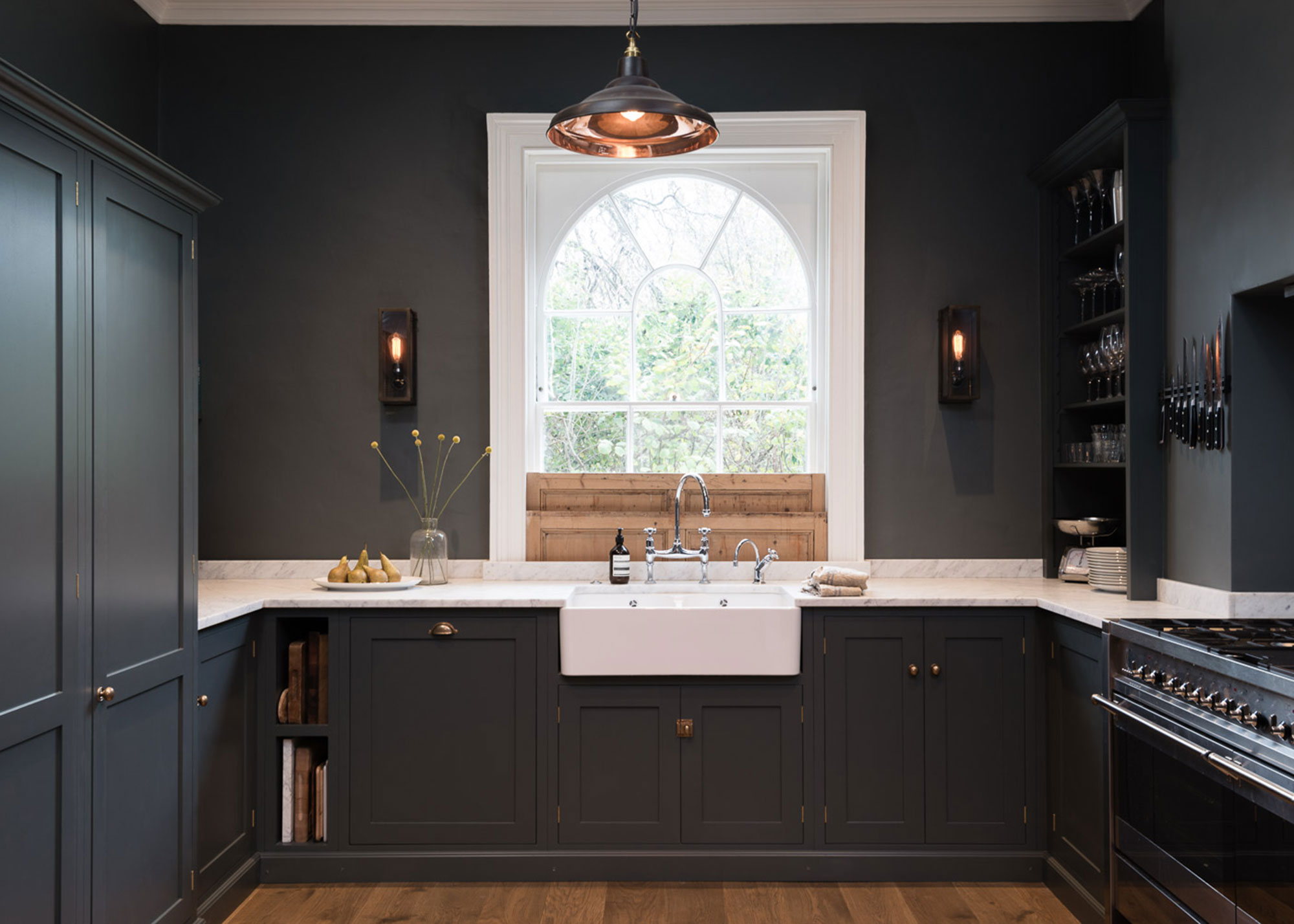 dark grey Shaker kitchen with white marble worktops and arched sash window with original shutters