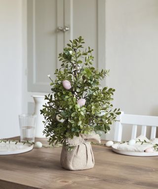 real tree with easter eggs on a dining table