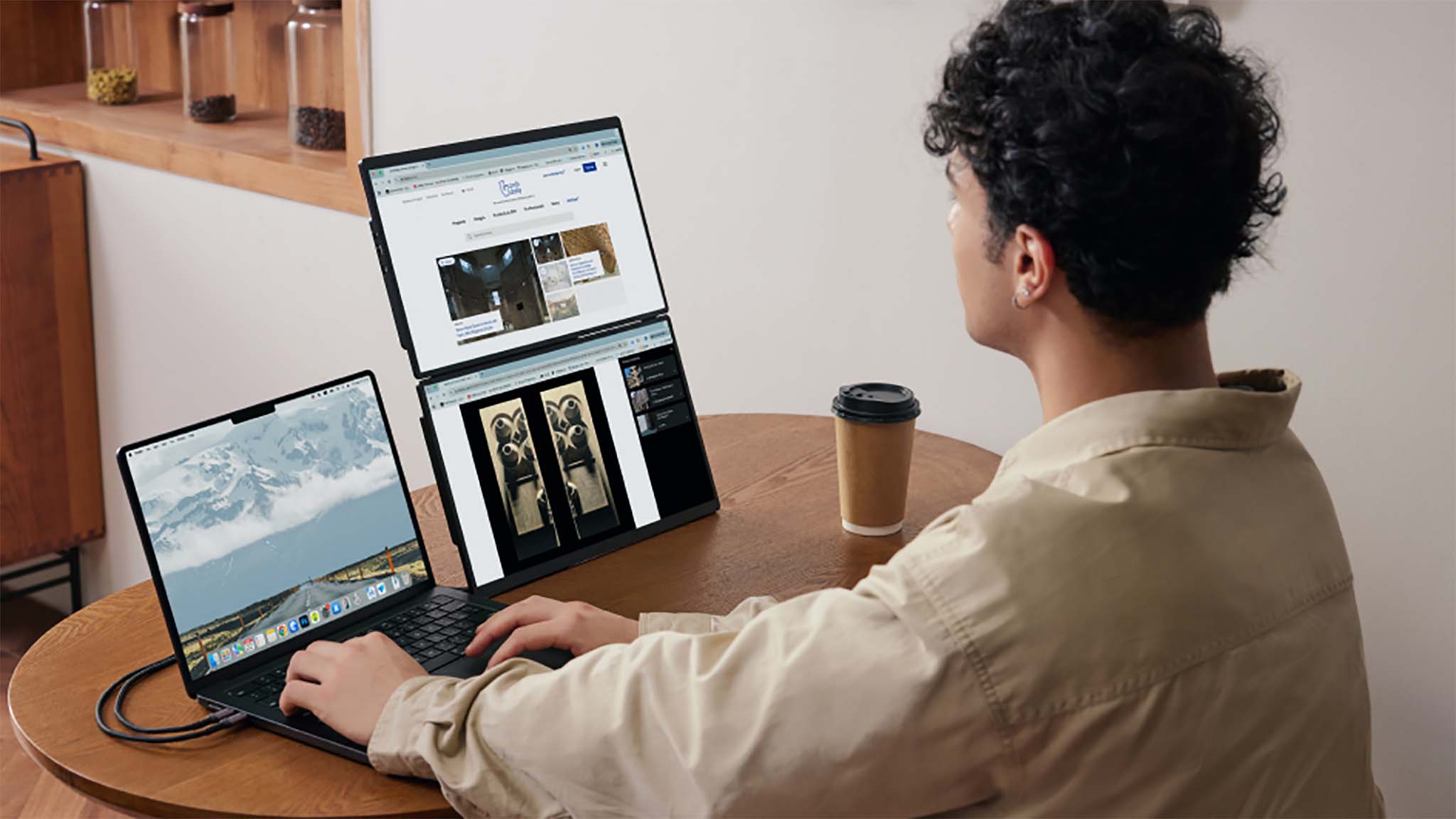 A man using the JSAUX FlipGo Horizon with the two accessory monitors stacked on top of each other.