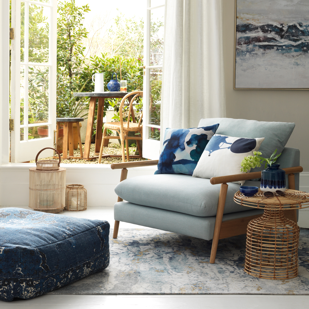 living room with white window and blue shade chair