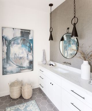 Neutral bathroom with gray wall and blue tones, black hanging pendants