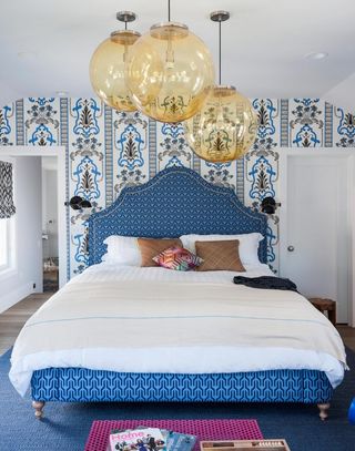 Blu bedroom with patterned wallpaper and yellow glass pendant lights