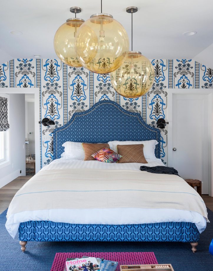 Blue bedroom with patterned wallpaper and yellow glass pendant lights