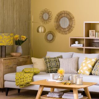 Yellow living room with wood effect feature wall, mirrors and white sofa
