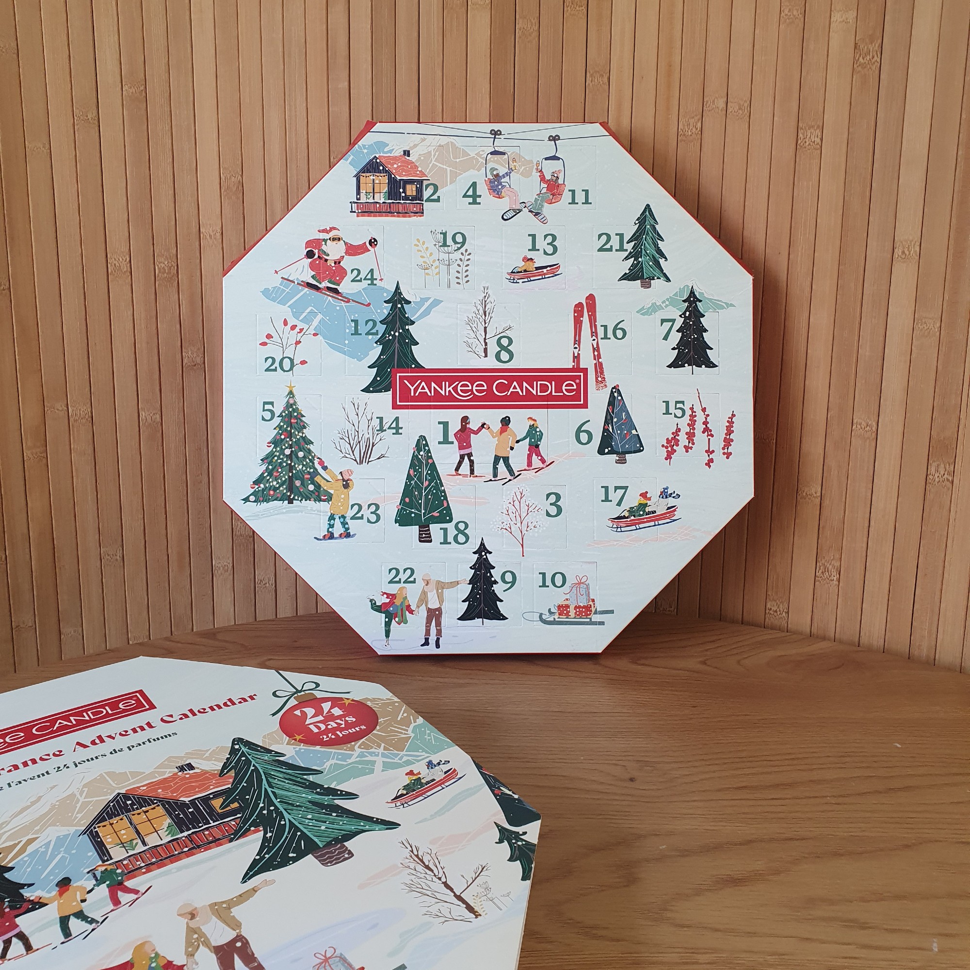 The Yankee Candle Wreath Advent Calendar leaning against a panelled backdrop