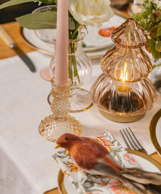 Cottagecore Christmas tablescape with tinted glassware and a bird figurine