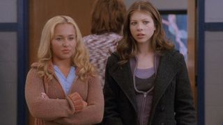 Hayden Panettiere standing with her arms crossed and Michelle Trachtenberg standing next to her. 