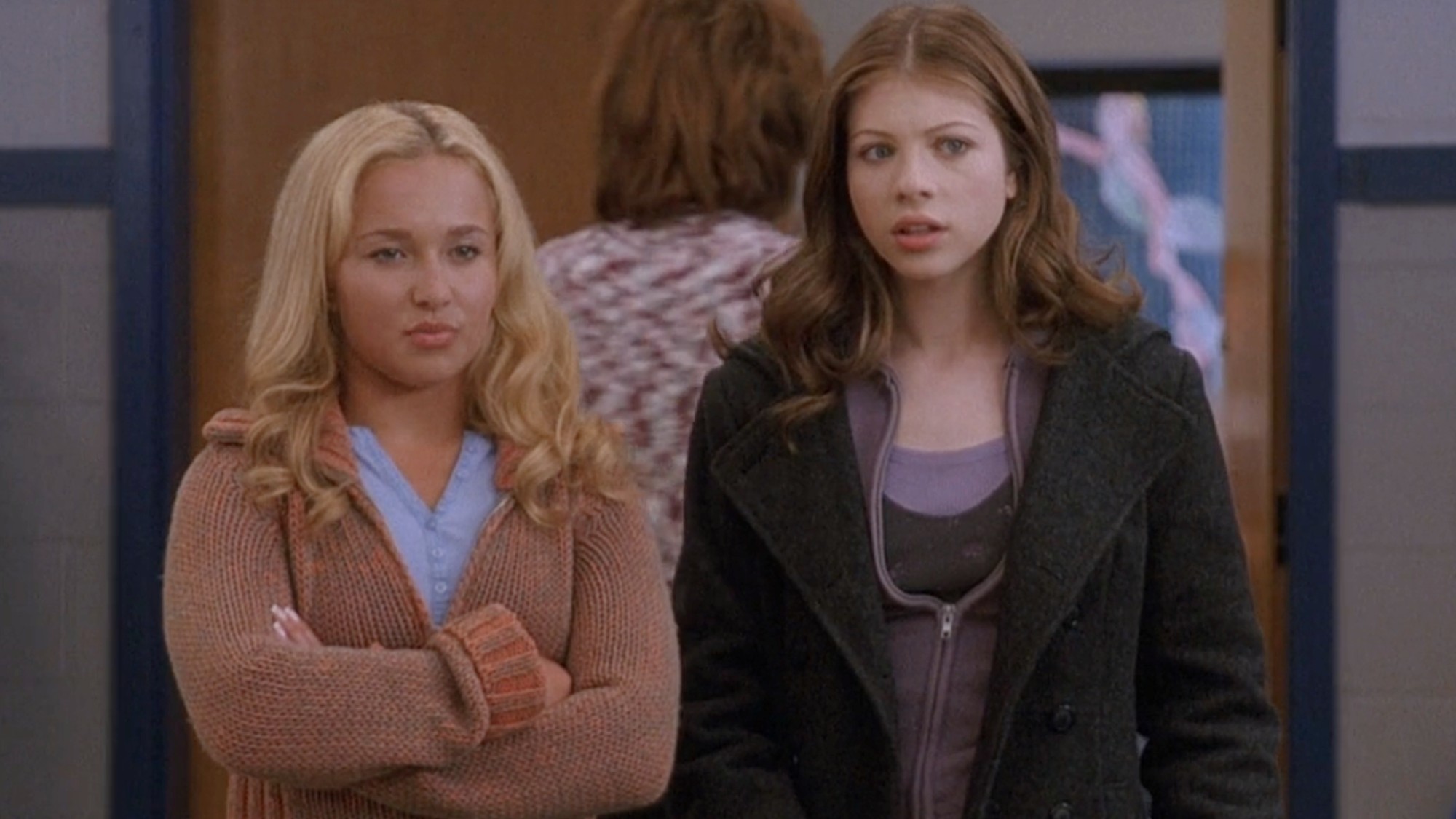 Hayden Panettiere standing with her arms crossed and Michelle Trachtenberg standing next to her. 