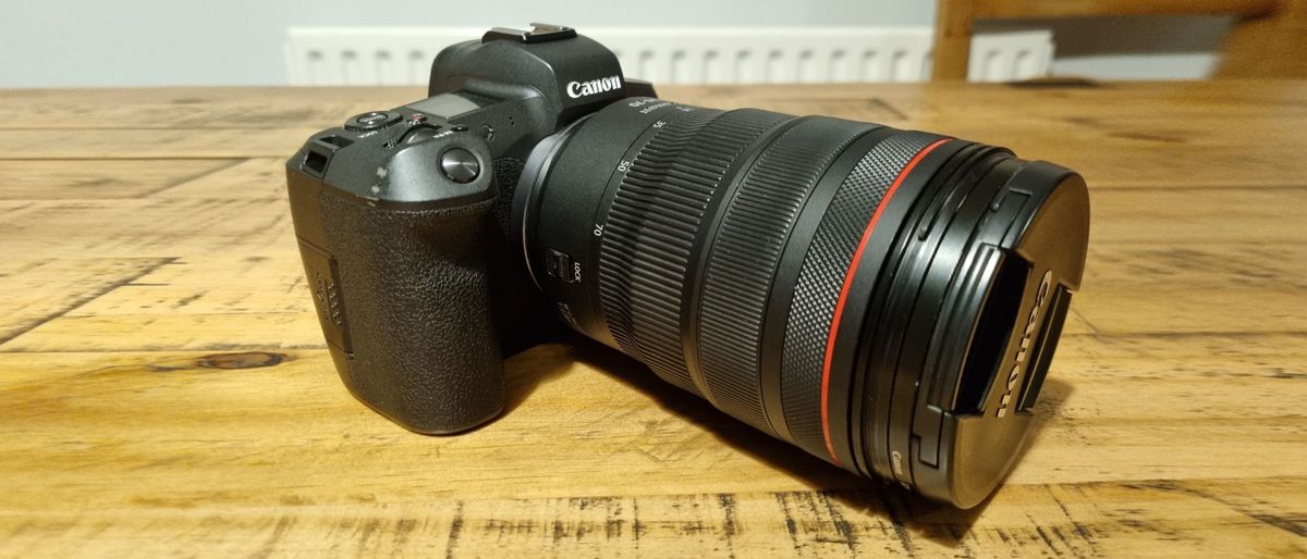 The Canon RF 24-70mm f/2.8L IS USM lens on a canon EOS R on a wooden table